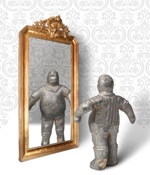 Composición que conforma la imagen de la exposición: muñeco de un futbolín antiguo mirándose al espejo.
