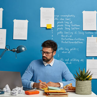 Estudiante trabajando sentado tras un escritorio