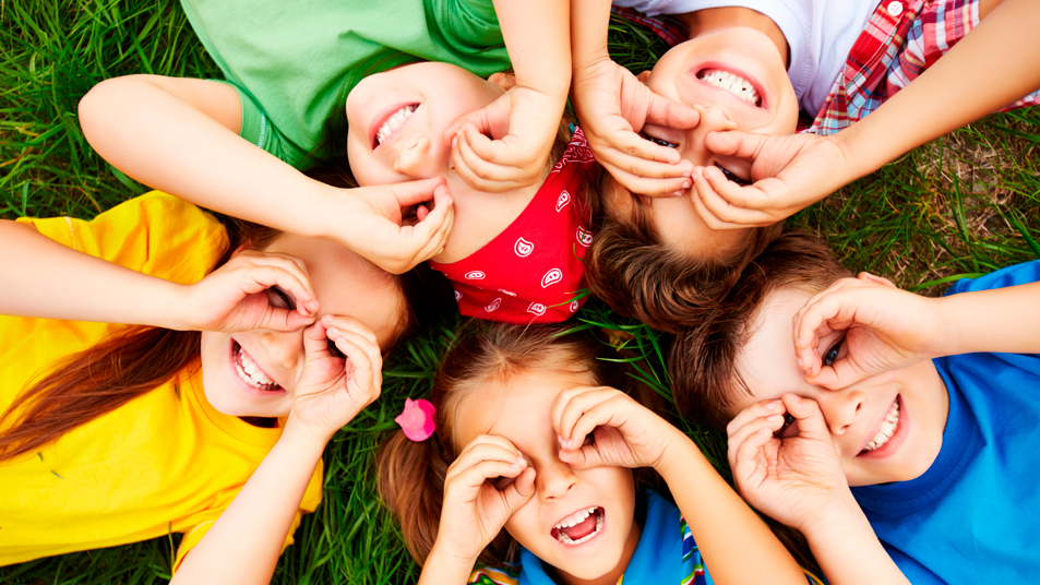 Niños y niñas jugando en la hierba