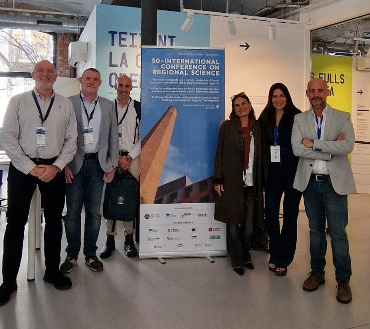 El equipo de ECO-GREEN ANALYTICS (IIDL – Universitat de València) ante el cartel del 50th International Conference on Regional Science, Barcelona 2026.