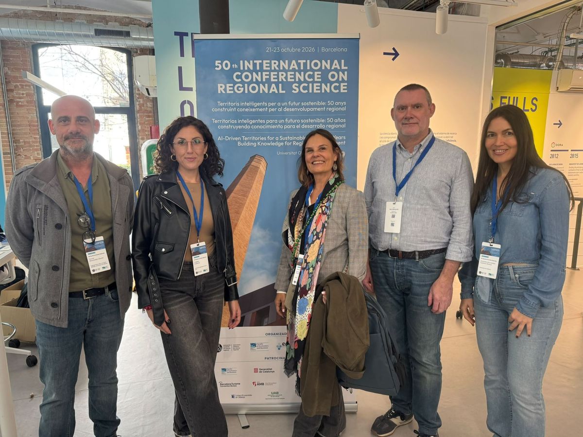 Integrantes de ECO-GREEN ANALYTICS (IIDL – Universitat de València) ante el cartel del 50th International Conference on Regional Science, Barcelona 2026.
