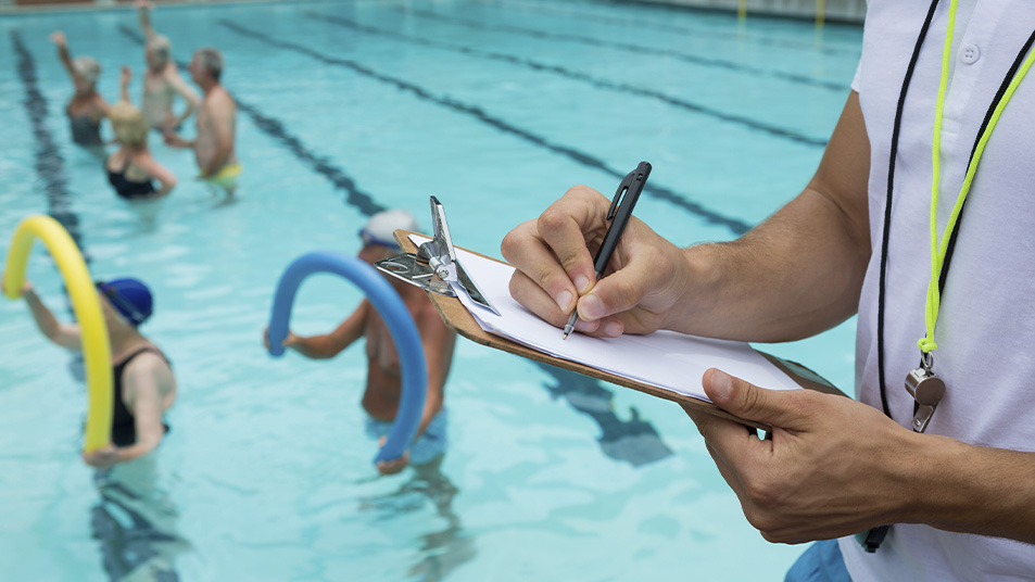 Investigador controlando a personas haciendo ejercicio en piscina