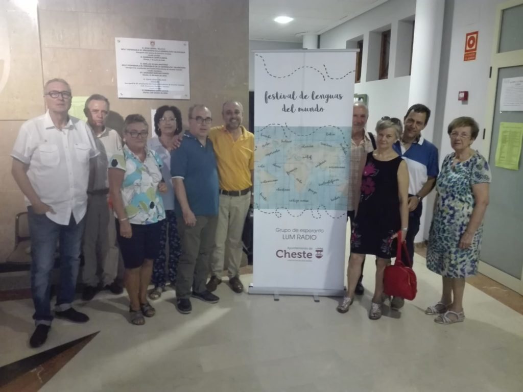 Miembros del grupo esperantista junto al cartel del Festival de Lenguas del Mundo
