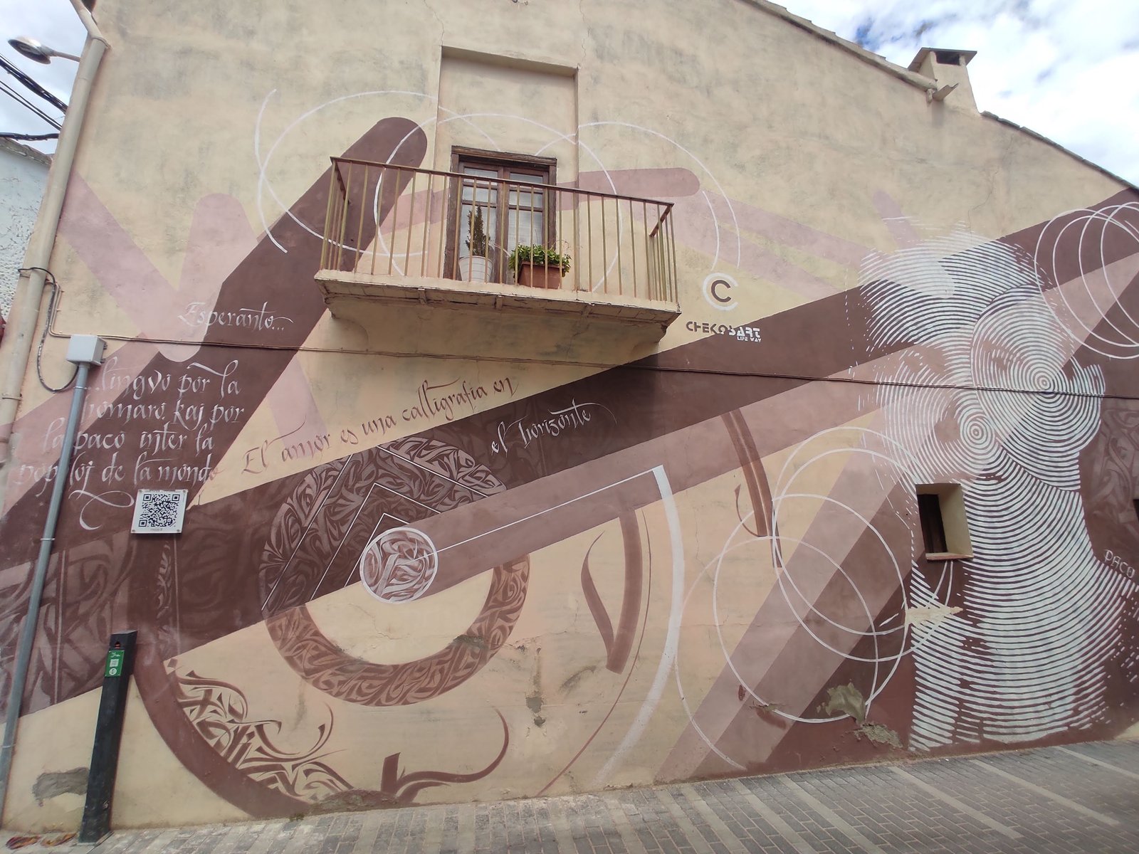 Mural caligráfico con textos en esperanto en una fachada de Cheste
