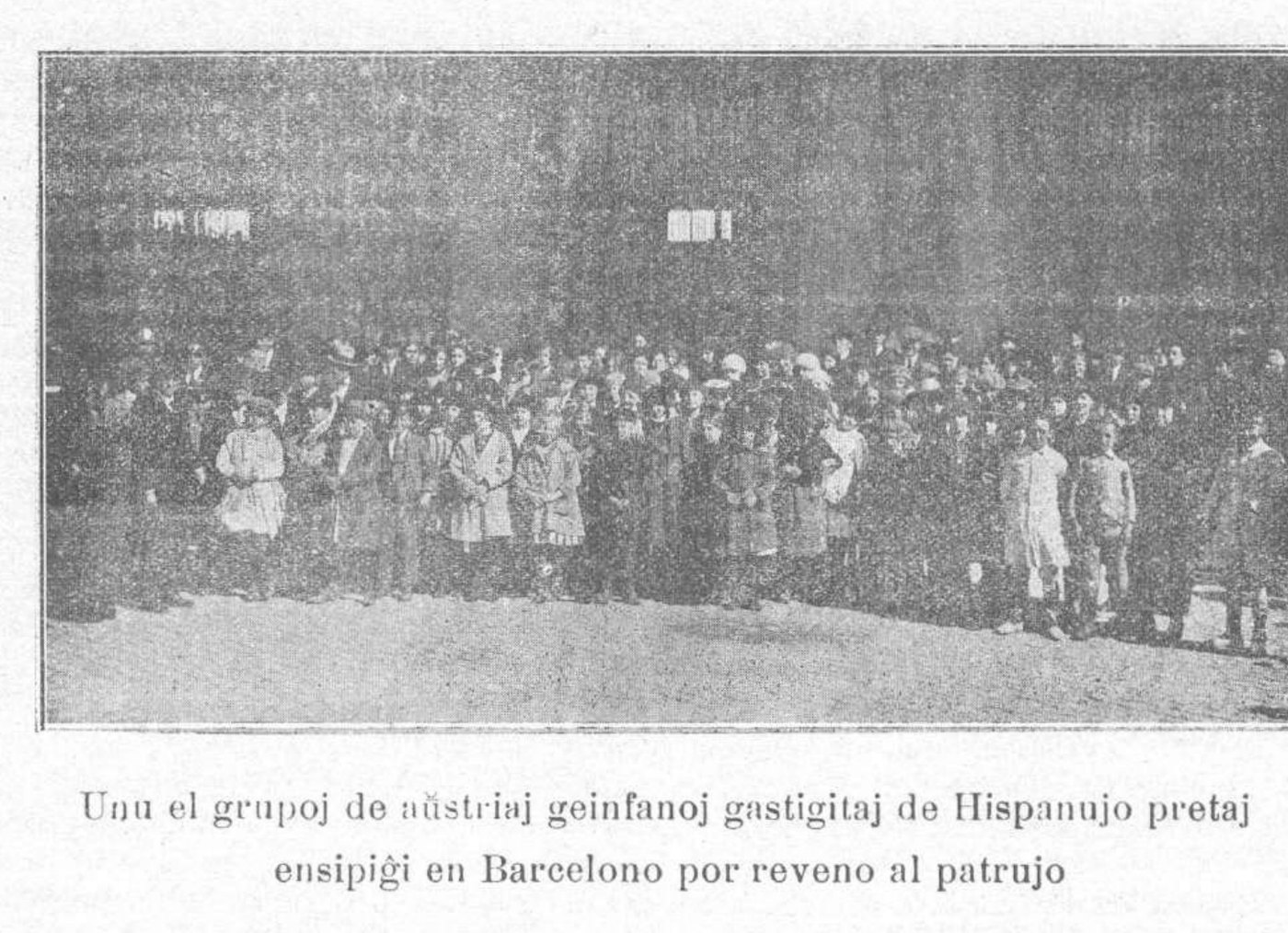 Fotografía de 1922 con un grupo numeroso de niños y adultos ante un edificio del puerto