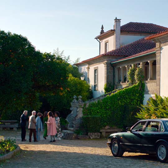 A group of people and a car in front of a house