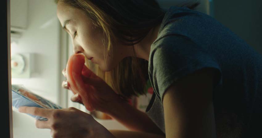 Una xica fent olor un tros de carn