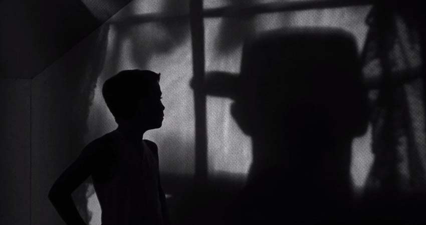 A boy in profile and a man with a hat on his back