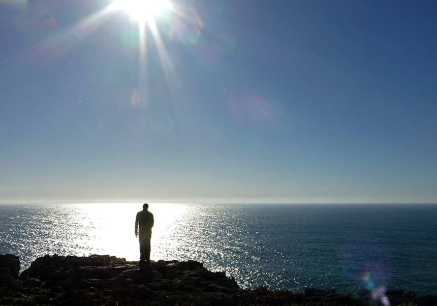 Una persona refugiada mira a l'horitzó de la Mediterrània. Foto amb llicència Creative Commons.