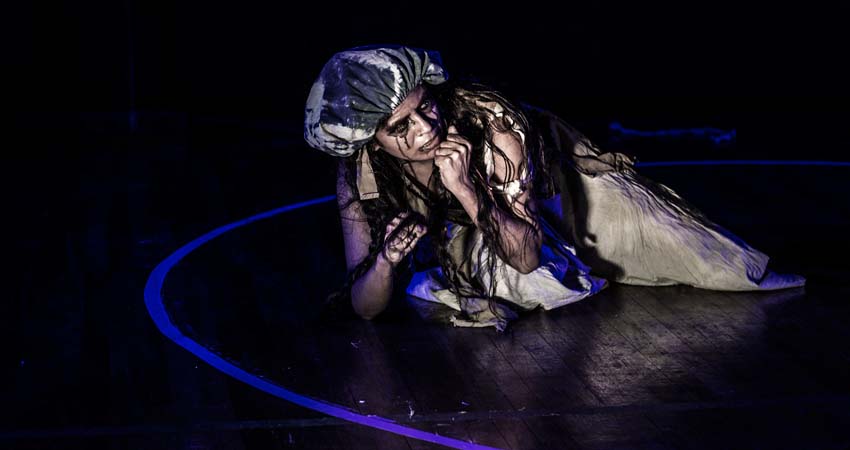 A person crouching on the stage