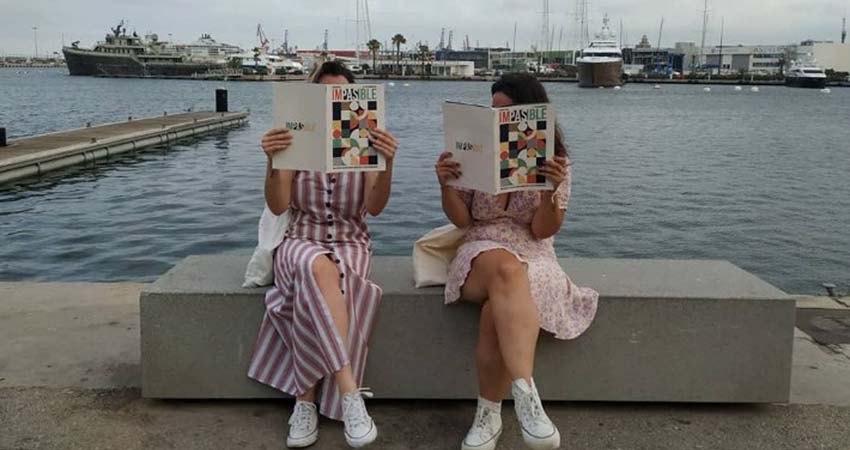 Two women sitting reading a magazine