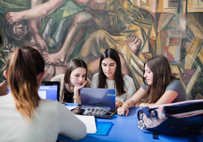 Cuatro estudiantes con portátiles.