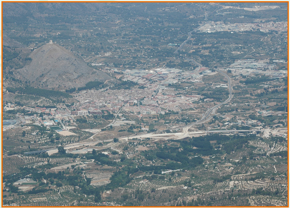Paisaje de una montaña y un valle valenciano con un pueblo. Vista aérea.