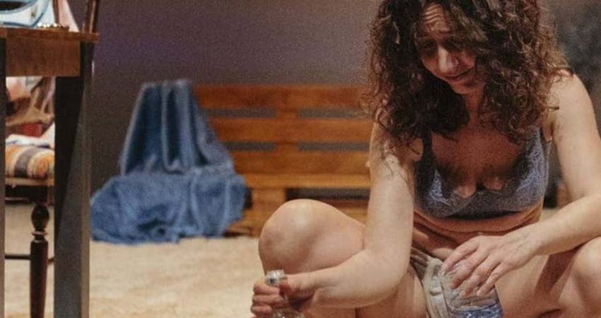 Crouching woman with a bottle and a glass