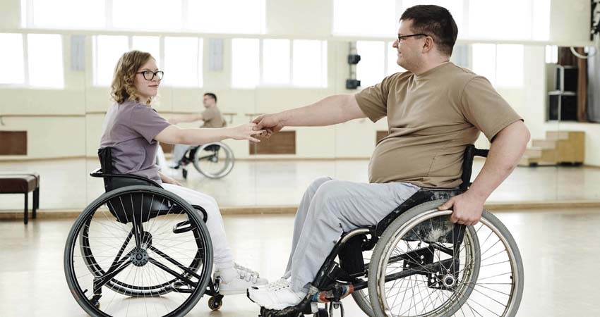 A man and a woman dancing in a wheelchair