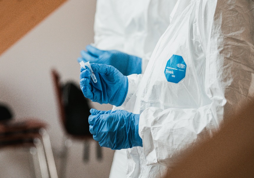 There is a person with gloves holding some eppendorf tubes