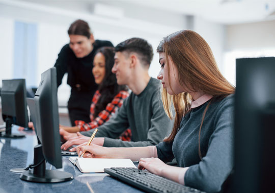 Group of people working in front of a computer.