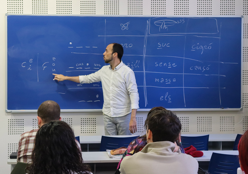Photo of the teacher pointing to a word written on the blackboard.
