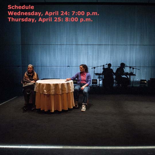 Two actresses in front of a table and two musicians in the background