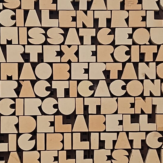 Mural amb text fet amb ceràmica