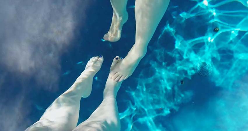 Las piernas de dos personas en una piscina
