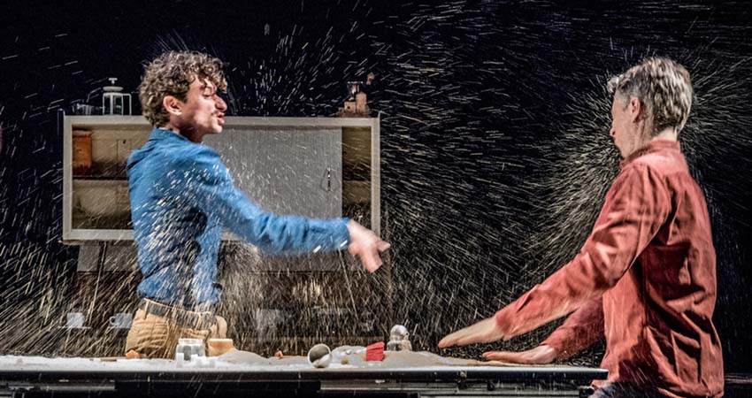 Two men on stage throwing water on each other
