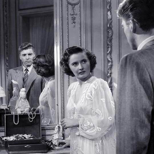 A man and a woman looking at each other and reflecting in a mirror