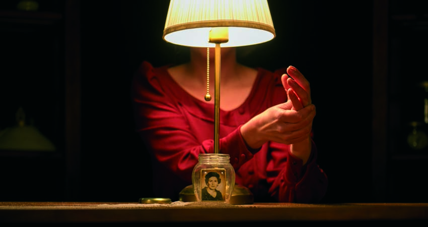 Mujer detrás de una lámpara con una fotografía