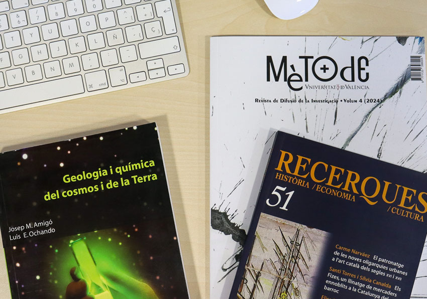 Imatge del esdeveniment:Llibres, revistes i altres publicacions acadèmiques damunt d'una taula al costat d'un teclat i un ratolí.