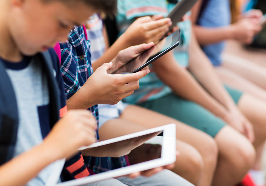 Estudiantes adolescentes con <i>tablets</i>.