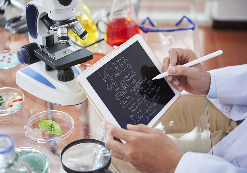 Hi ha una persona treballant amb una tauleta en un laboratori