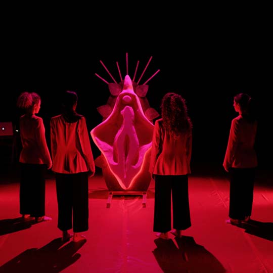 Quatre dones d'esquena en un escenari