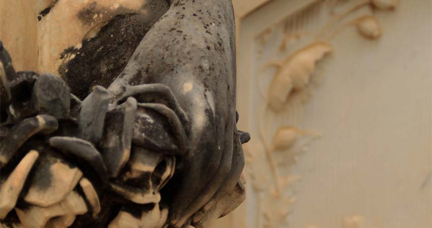 Escultura de una mano con una flor