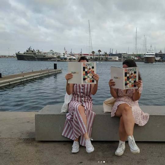 Dos mujeres sentadas leyendo una revista