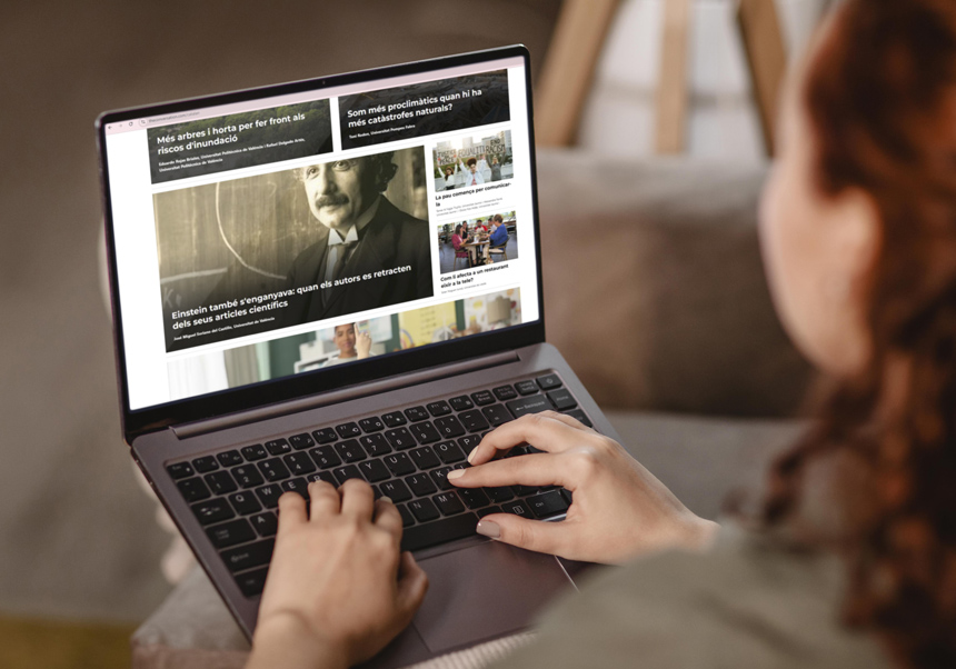 Una investigadora lee <i>La Conversa</i> en su ordenador portátil.