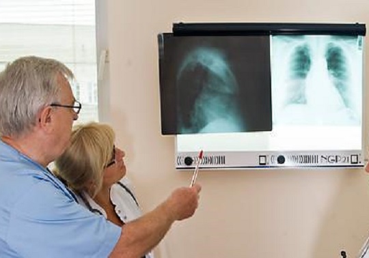Imagen de dos personas del área de la medicina revisando un problema médico.