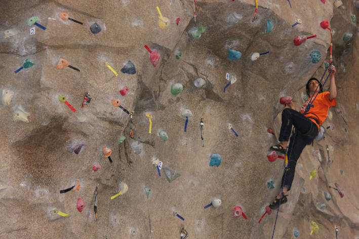 Una dona practica l'escalada en el recòdrom.