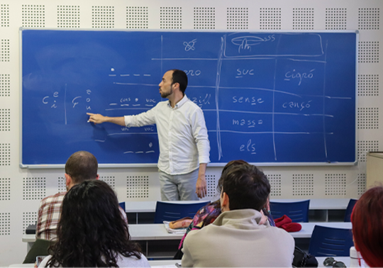 Photo of the teacher pointing to a word written on the blackboard.