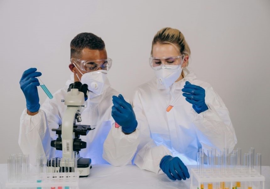 There are two people working with protective suits