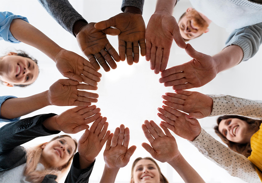 Personas con las manos juntas como en un equipo.