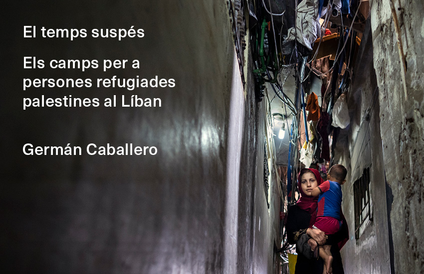 Una dona carrega amb el seu fill per un carrer del camp de refugiats