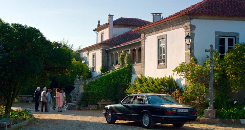 A group of people and a car in front of a house