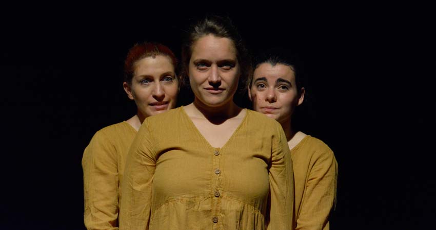Tres dones dempeus, una davant i les altres darrere d'ella