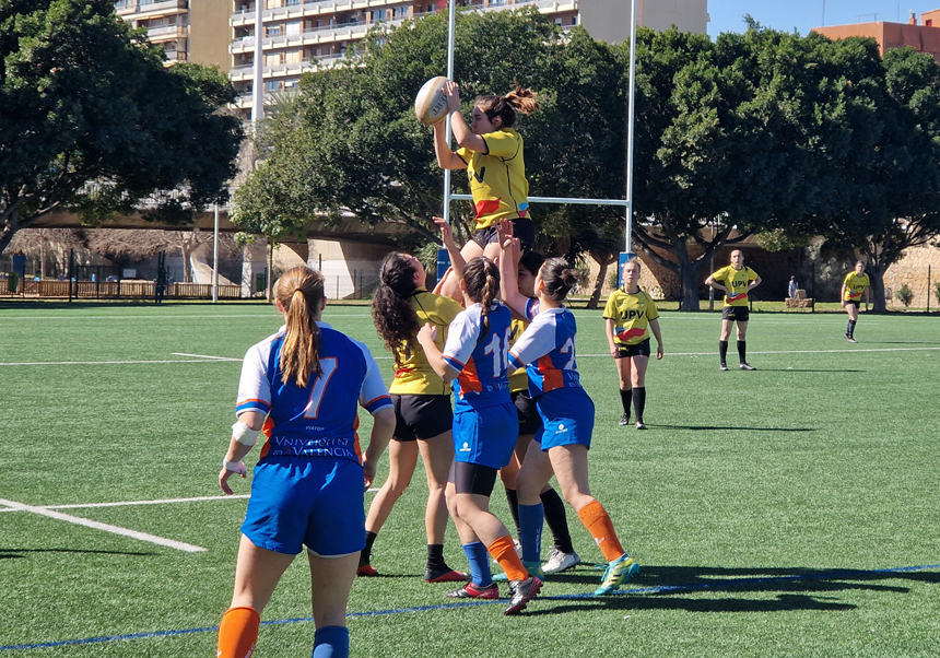 Rugby players reaching for the ball in the air