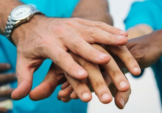 Close-up photo of various hands together
