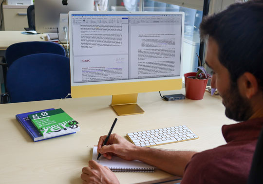 Técnico lingüístico traduciendo un texto institucional con el ordenador.