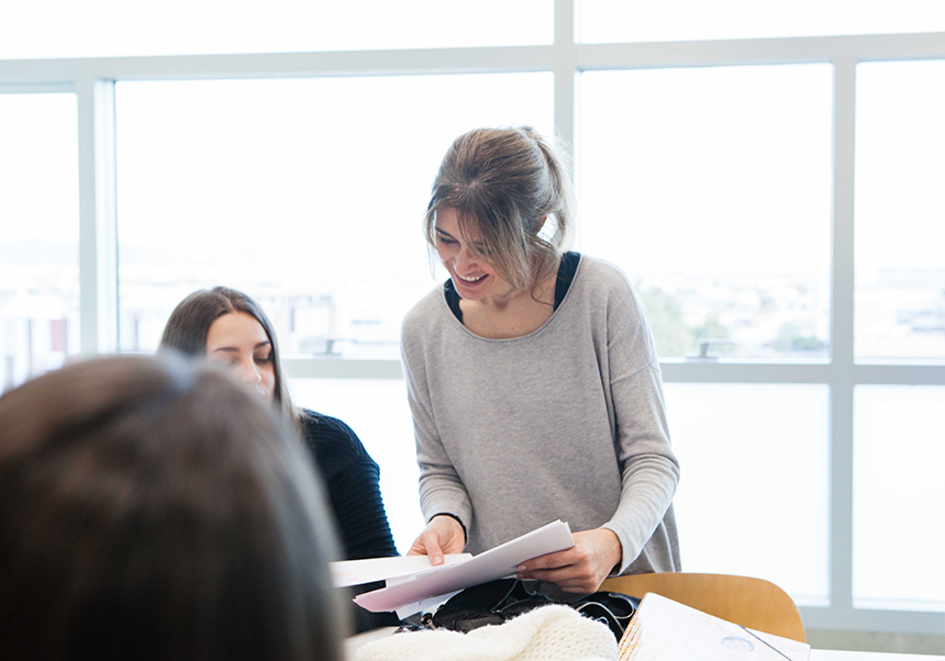 Professora revisant treball alumnes