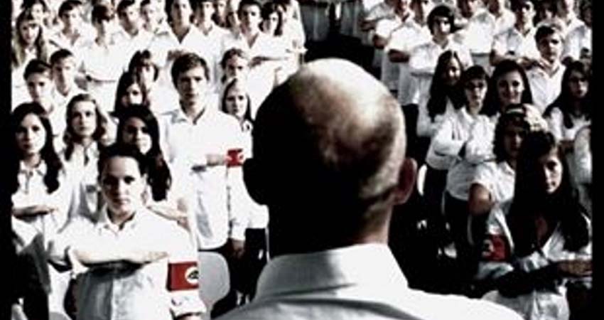 Poster detail. A man with his back turned talking to a group of young people