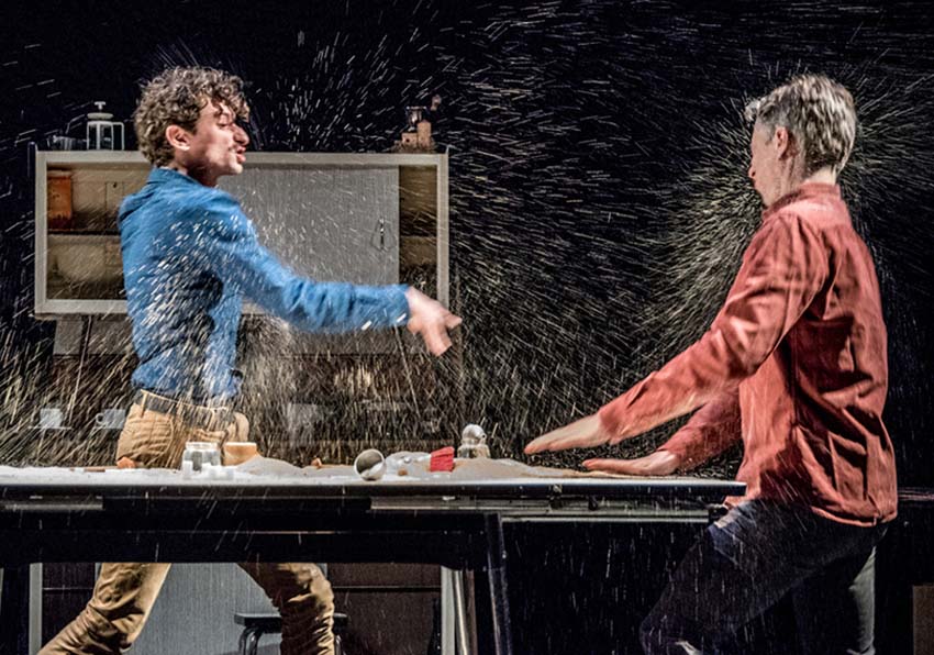Two men on stage throwing water on each other