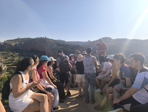 Imagen de un profesor dando clase a sus alumnos en un mirador del municipio de Castielfabib